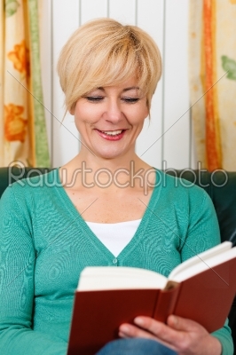 Mature woman is reading a book