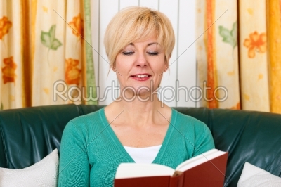 Mature woman is reading a book