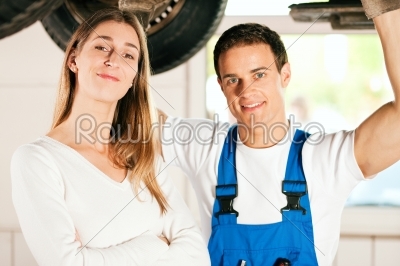 Mechanic repairing car of woman