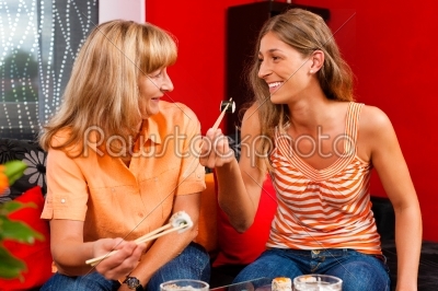 Mother and daughter eating sushi