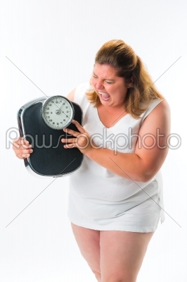 obese woman looking angry at scale