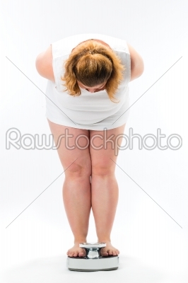 Obese young woman standing on a scale