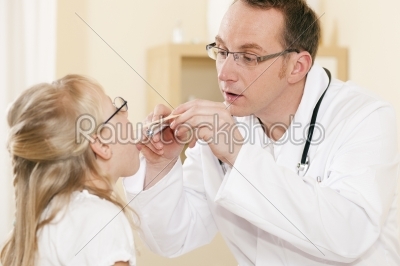 Pediatrician doctor examining throat of girl