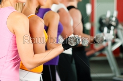People in gym exercising with dumbbells 