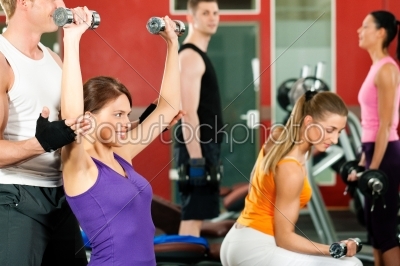 People in gym exercising with weights