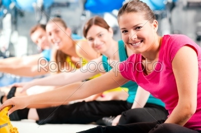 People in gym warming up stretching