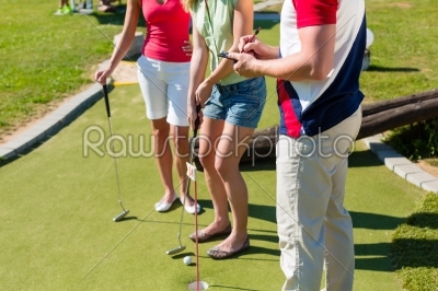 People playing miniature golf outdoors