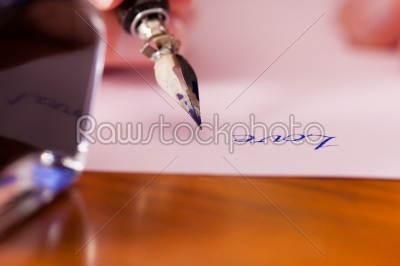 person writing a love letter with pen and ink