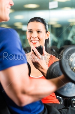 Personal Trainer in gym and dumbbell training