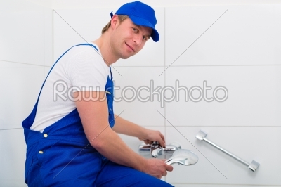 Plumber repairing shower in bath room