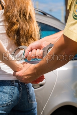 Police officer arresting a woman with handcuffs