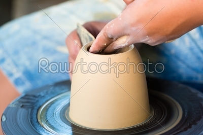 Potter creating clay bowl on turning wheel