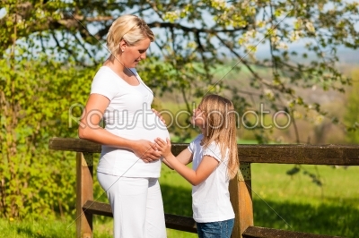pregnancy - girl touching belly of pregnant mother