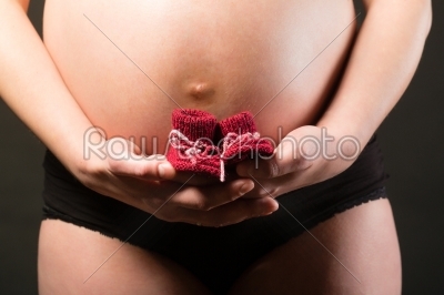 Pregnant woman and baby shoes 
