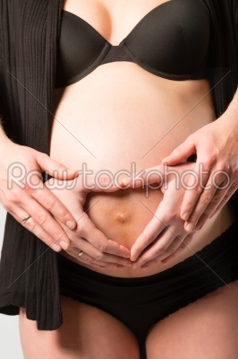 Pregnant woman touching her belly or  baby bump