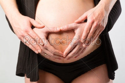 Pregnant woman touching her belly or  baby bump