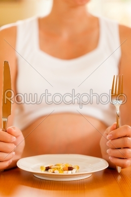 pregnant woman with plate full of pills