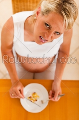 pregnant woman with plate full of pills