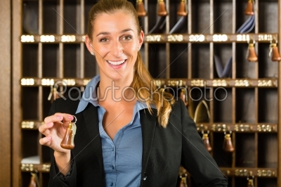 Reception of hotel - woman holding key in hand