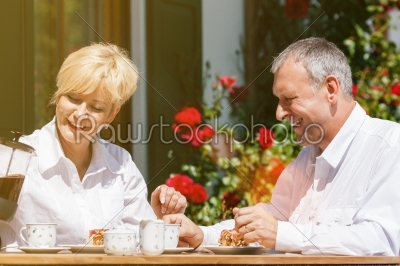 Senior couple in garden with coffee