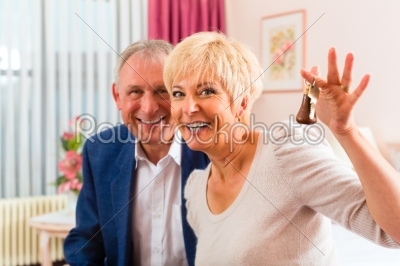 Senior couple sitting on bed in hotel room