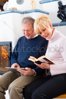 Seniors at home in front of fireplace