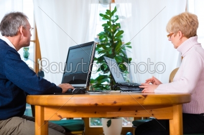 Seniors at home working on computer