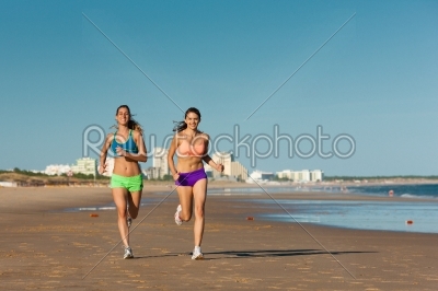 Sport and Fitness - people jogging on beach