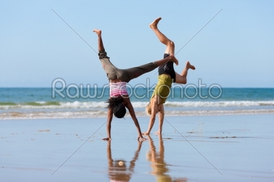 Sport couple doing gymnastics on the beach