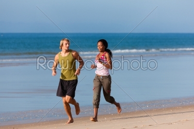 Sport couple jogging on the beach