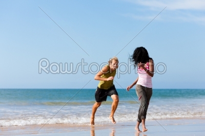 Sport couple playing  on the beach