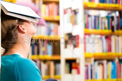 student in library tired and overworked
