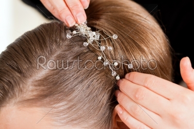 Stylist pinning up a bride_qt_s hairstyle