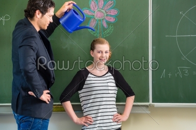 Teacher motivating school student in front of the board