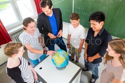 Teacher teaching students geography lessons in school