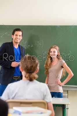Teacher testing  student  in math lessons in school class