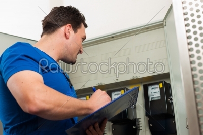 Technician reading the electricity meter
