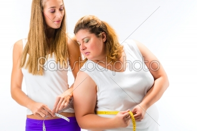 Thin and fat woman measuring waist with tape