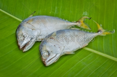 two boiled mackerel fish on green banana leaf