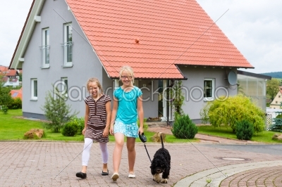 Two girl or children walking with dog