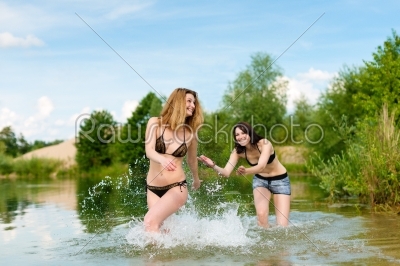 Two happy women having fun at lake