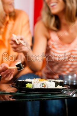 Two women eating sushi