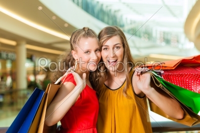 Two women shopping with bags in mall