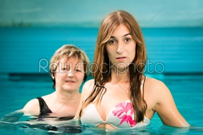 Wellness - mature and young woman in swimming pool
