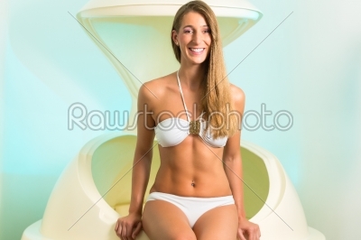 Wellness - young woman floating in Spa in tank