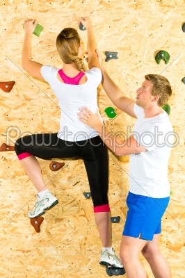 Woman and man climbing at climbing wall
