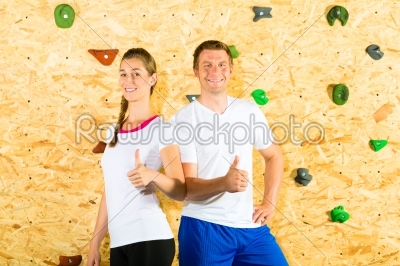 Woman and man standing at climbing wall