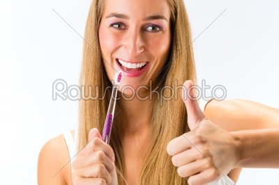 Woman brushing her teeth with a toothbrush