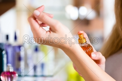 woman buying perfume in shop or store