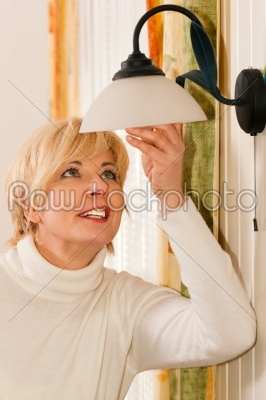 Woman changing a light bulb